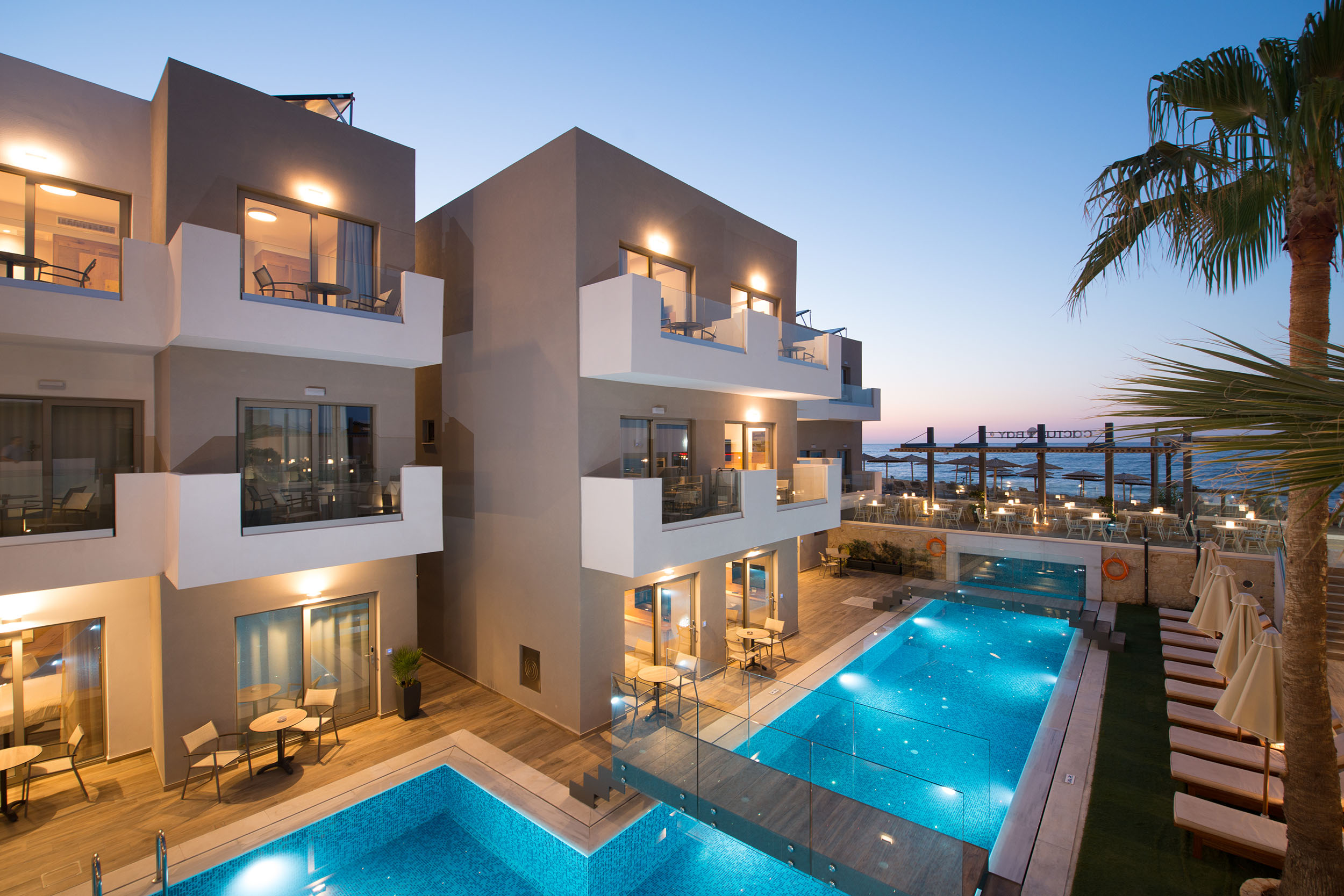 Exterior evening view of Cactus Bay Hotel rooms, pool bar and rooms