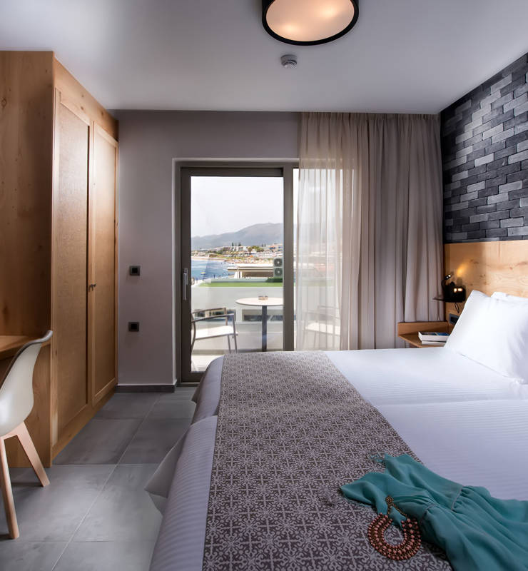 Σουίτα ξενοδοχείου Cactus bay με ένα διπλό κρεβάτι μία τηλεόραση και μπαλκόνι με θέα την θάλασσα