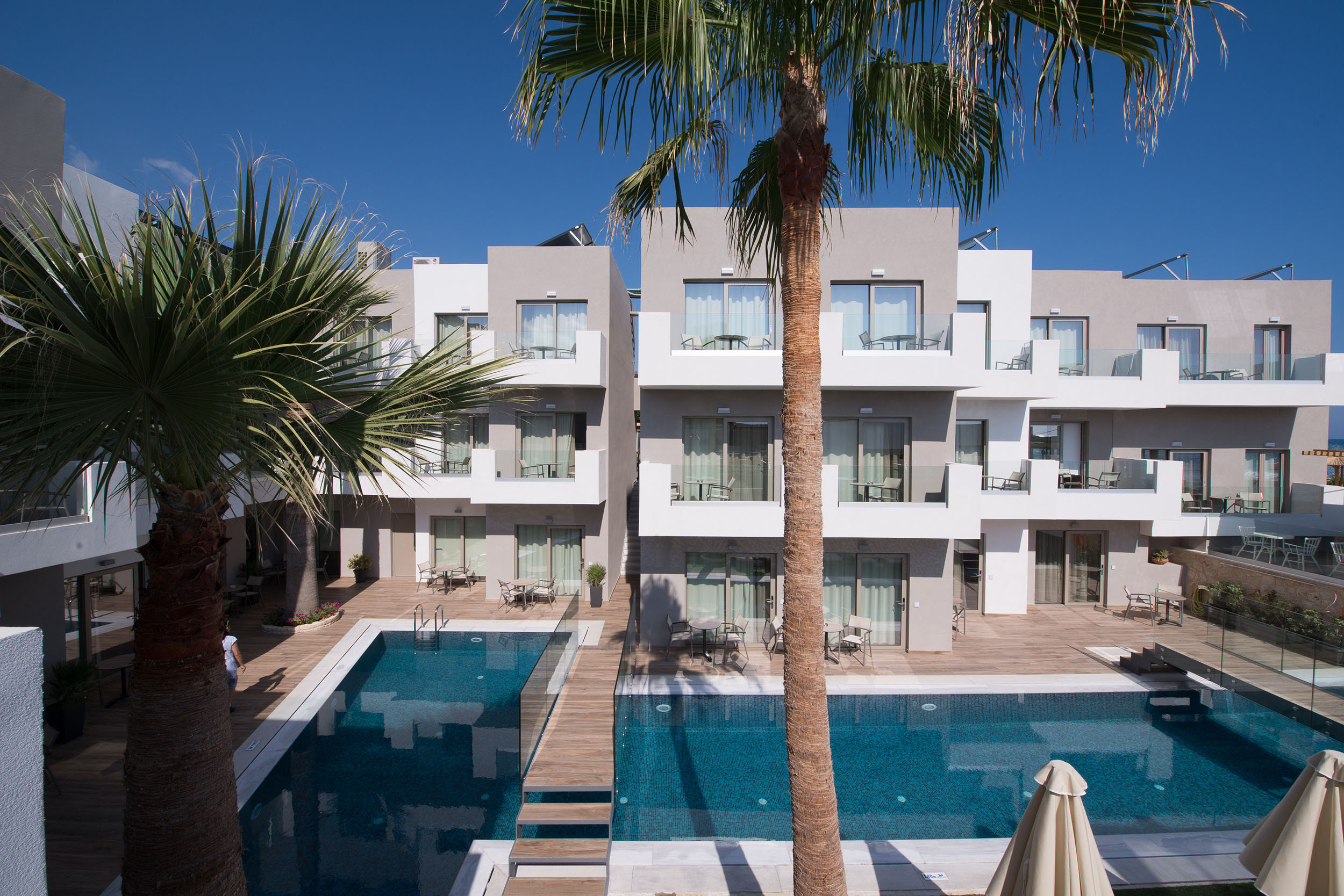 Hotel view overlooking palm trees and swimming pool at Cactus Bay Hotel